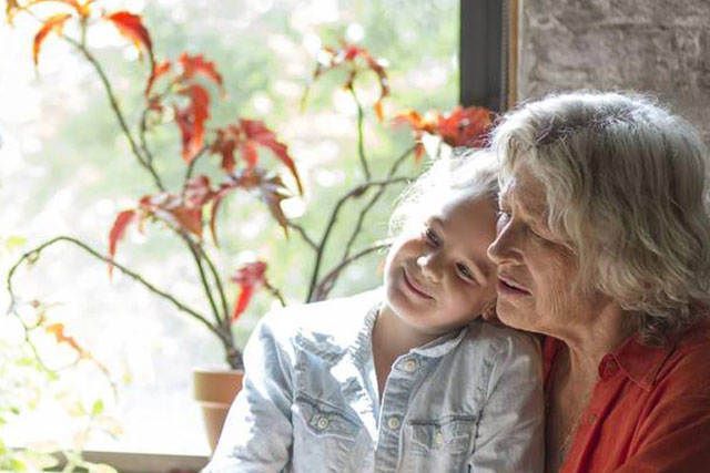 Barnbarn och mormor i kök. re:member erbjuder individuell ränta.