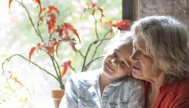 Barnbarn och mormor i kök. re:member erbjuder individuell ränta.
