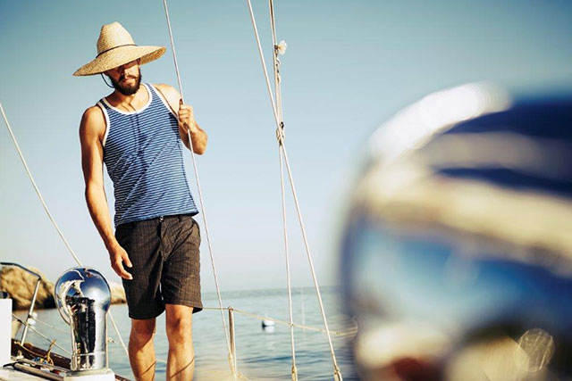 Man med solhatt på båt - Betala din Greklandsresa med ett kreditkort från re:member