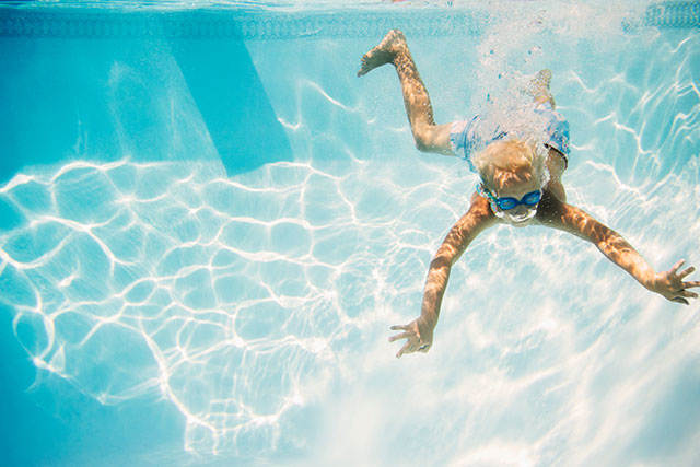 Pojke dyker i klistallblått vatten - Betala ditt dykarcertifikat med ett kreditkort från re:member